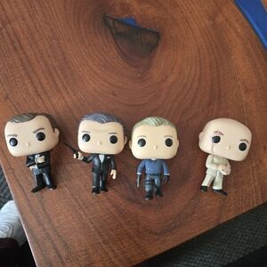 Funko Pop Figures with Black, Gray, and Cream Outfits From James Bond Movies
